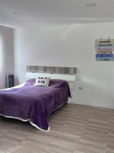 a bedroom with a bed with a purple blanket at Puesta del Sol Apart in Río Gallegos