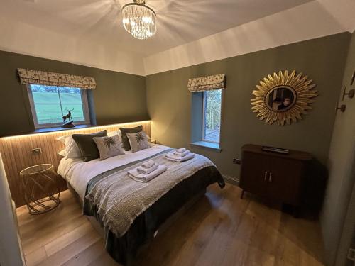 a bedroom with a large bed with a mirror on the wall at Broombarns Farm Cottage in Forgandenny
