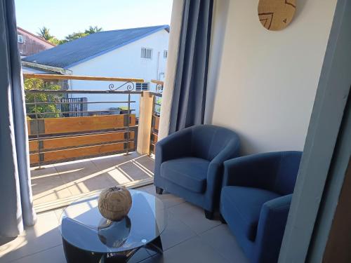 a room with two chairs and a table and a balcony at Gîte Holidays mon repos in Saint-André