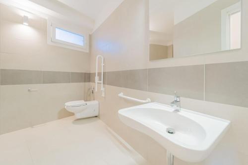 a white bathroom with a sink and a toilet at Residence Padulella - Goelba in Portoferraio