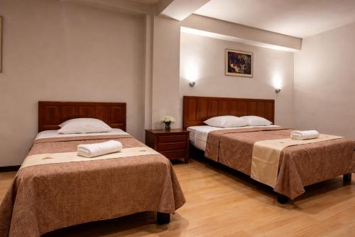 two beds in a hotel room with towels on them at Hotel Safari in Iquitos