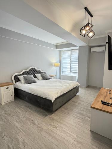 a bedroom with a large bed and a desk at Boulevard terrace apartment in Chişinău