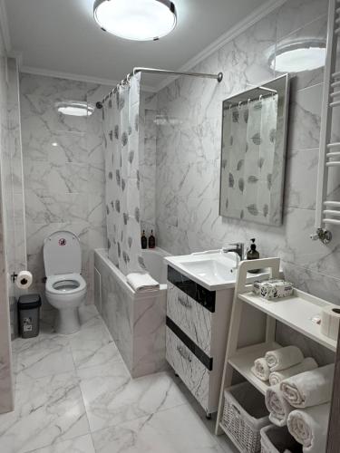 a white bathroom with a sink and a toilet at Boulevard terrace apartment in Chişinău
