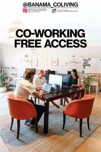 a group of people sitting at a table with laptops at Banama Surfhouse - Coliving Coworking & Yoga in Corralejo