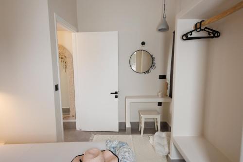 a room with a bed and a mirror and a table at EOS Small House in Pollonia