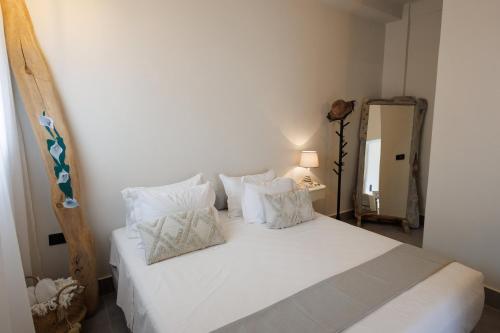a bedroom with a bed with white sheets and pillows at EOS Small House in Pollonia