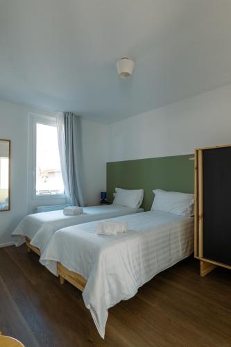 two large beds in a room with a window at Il Platano Guest House in Quartino