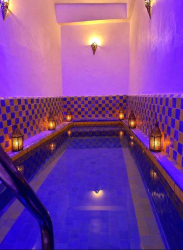 a swimming pool in a room with purple lighting at RIAD YOUSSEF in Fez