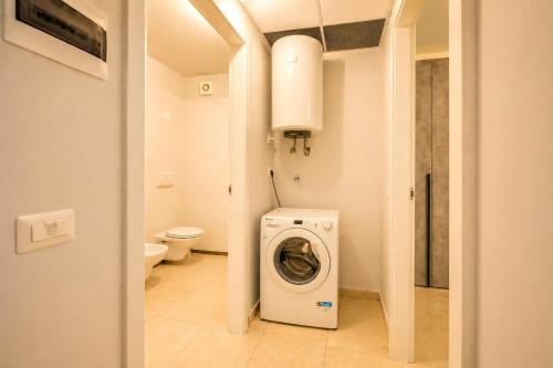 a bathroom with a washing machine and a toilet at Appartamento Residence Mimose - con parcheggio e Terrazza vicino al mare in Eraclea Mare