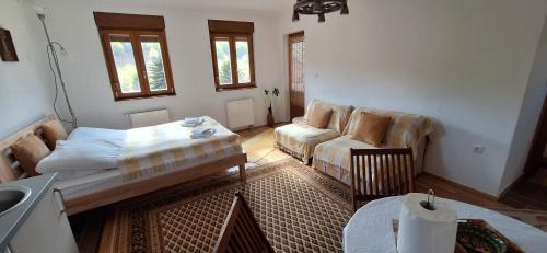 a living room with a couch and a table at Apartmani Jelenača prizemlje in Trnovo