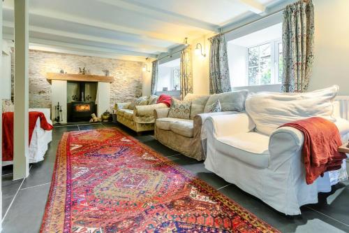 a living room with a couch and chairs and a fireplace at 4 Bed in Looe oc-p00795 in Lansallos