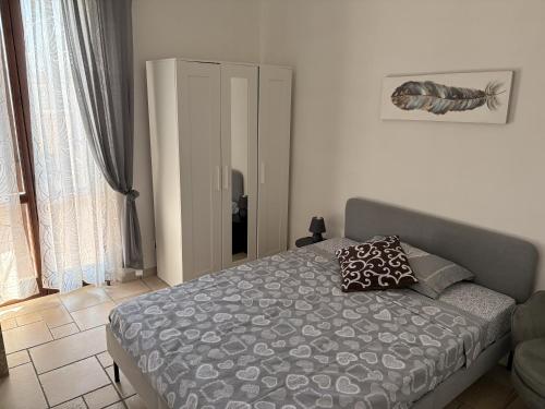 a bedroom with a bed with a gray comforter at Novara Il Gallo in Lumellogno