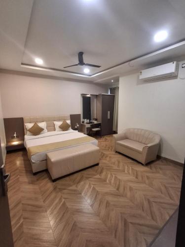 a large bedroom with a bed and a couch at Prakhyat in Maheshwar