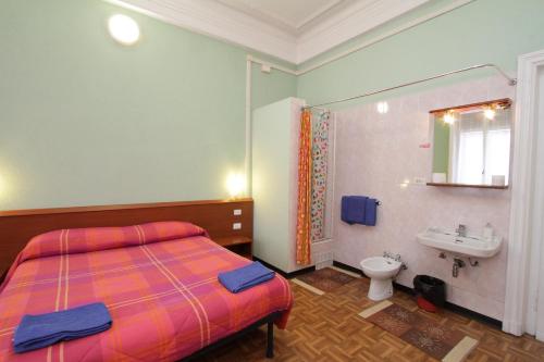 a bedroom with a bed and a sink and a toilet at Hotel Barone in Genoa