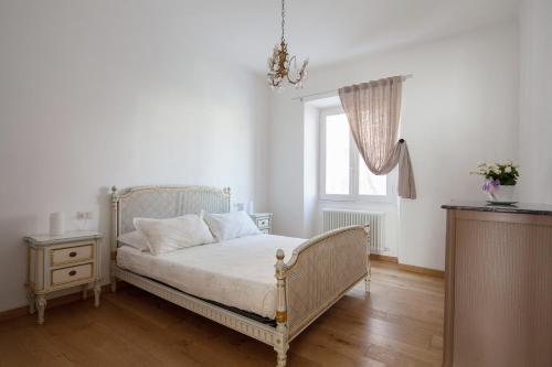 Un dormitorio blanco con una cama y una ventana. en Appartamento Vela Verde, en Sestri Levante