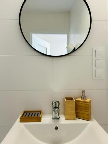 a bathroom sink with a mirror on top of it at Pokoje u Strażaka in Krościenko