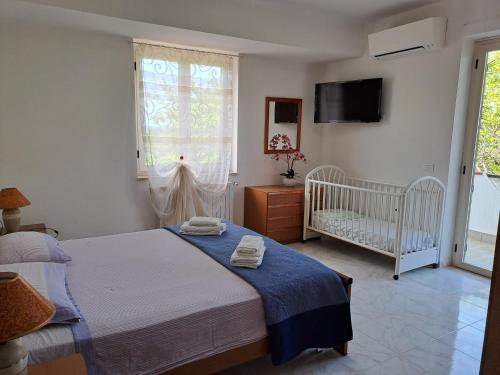 a bedroom with a bed and a crib and a window at Villa Anna Tropea in Tropea