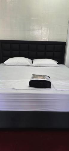 a bed with white sheets and a black head board at Aliya Stay in Galle