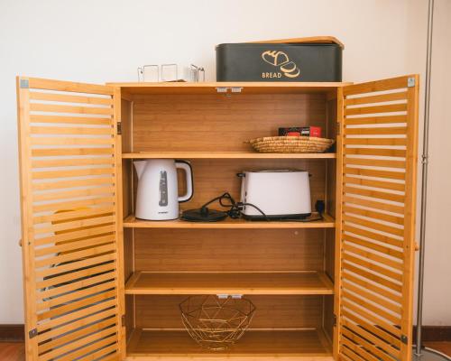 a wooden book shelf with a appliance on it at Alojamento Da Cunha in Chaves