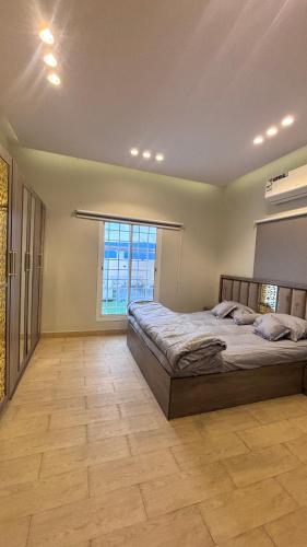 a bedroom with a bed and a large window at شاليه الجاكرندا 8 in Taif