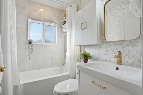 a bathroom with a sink and a tub and a toilet at Bright & Fully Renovated Retreat - Holiday Home in Saskatoon