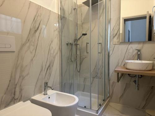 a bathroom with a glass shower and a sink at Suite LA BARONESSA in Lecce