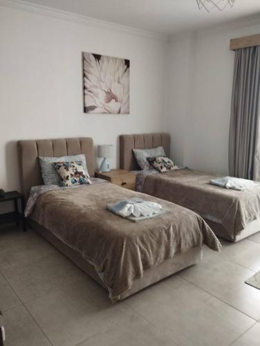 a bedroom with two beds and a painting on the wall at Royal Life Poseidon Residences Long Beach in Iskele