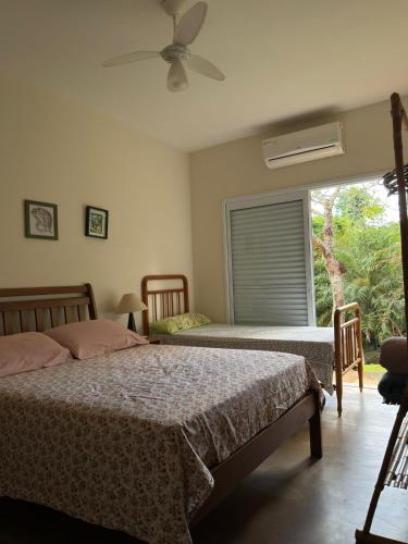 two beds in a bedroom with a window at Morada do Ipê Pousada in Chapada dos Guimarães