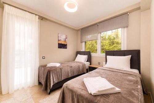 a room with two beds and a window at VALLEY Premium House in Serres