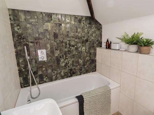 a bathroom with a bath tub and a toilet at Snowdrop Cottage in Morpeth