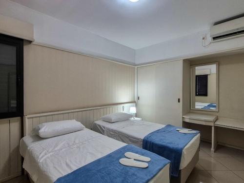 a hotel room with two beds and a window at Apartment 116 - Jundiaí in Jundiaí