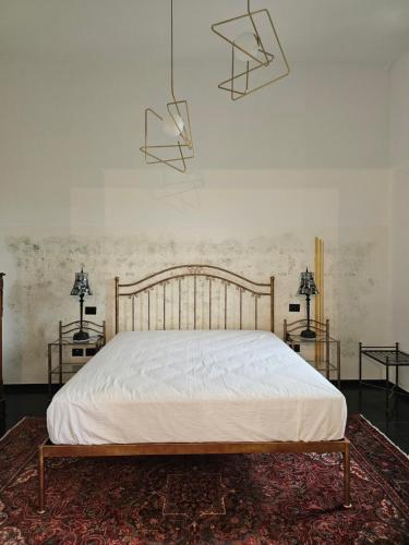 a bed in a room with two tables and two lamps at Rocca Contrada in Arcevia