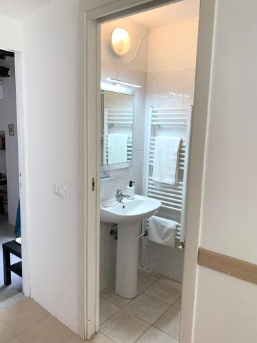 a white bathroom with a sink and a mirror at CiroMenotti62 in Marina di Carrara