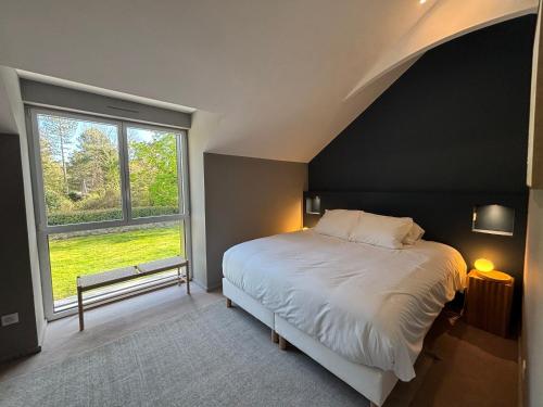 a bedroom with a large bed and a large window at Villa Le Touquet, piscine privée, 4 chambres in Le Touquet-Paris-Plage