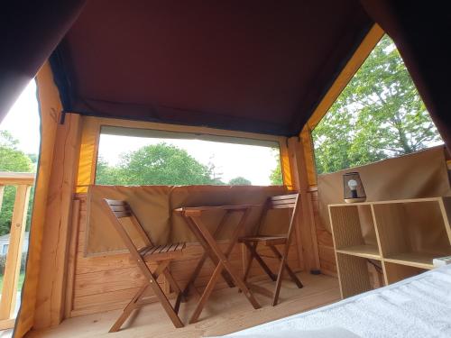 a room with two chairs and a window in a tent at Camping La Bâtisse in Réalmont