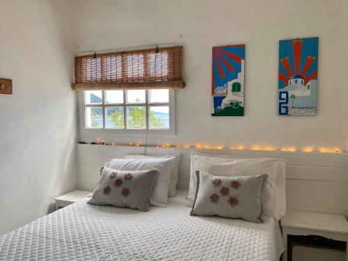 a bedroom with a white bed with two pillows at Boat House in Loutraki