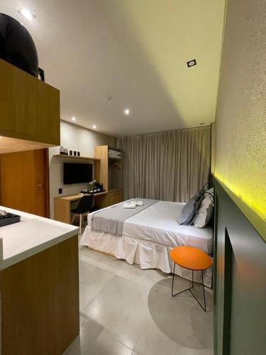 a bedroom with a bed and a desk and a kitchen at Ap 101 concept BobZ in Barrinha