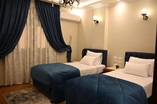 a hotel room with two beds and a window at Nabo House in Abu Simbel