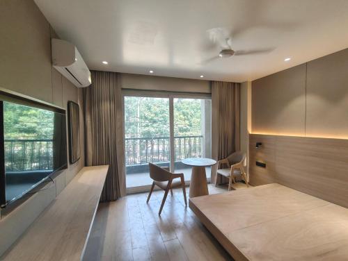 a living room with a table and a balcony at Hotel Radha residency inn in Chhatikara