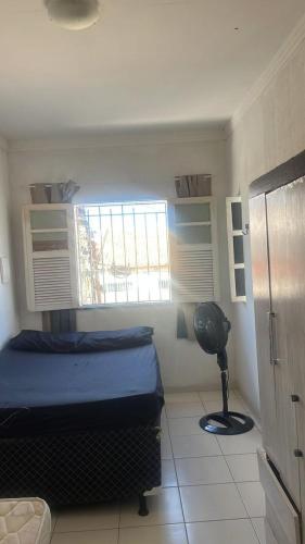 a bedroom with a bed and a window and a fan at Casa mobiliada Jabutiana in Aracaju