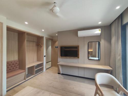 a living room with a tv and a mirror at Hotel Radha residency inn in Chhatikara