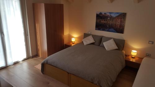 a bedroom with a large bed with two lamps at Villa Ducati in Vattaro