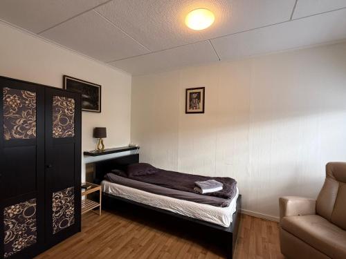 a small bedroom with a bed and a couch at Two room warm apartment Östavall in Östavall