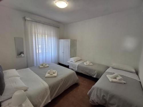 a bedroom with two beds with white towels on them at Casa Framida in Cecina