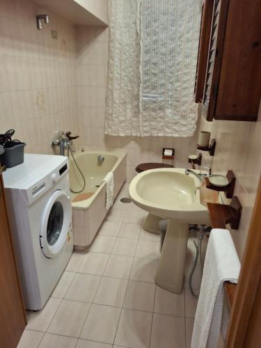 a bathroom with a washing machine and a sink at Casa Framida in Cecina