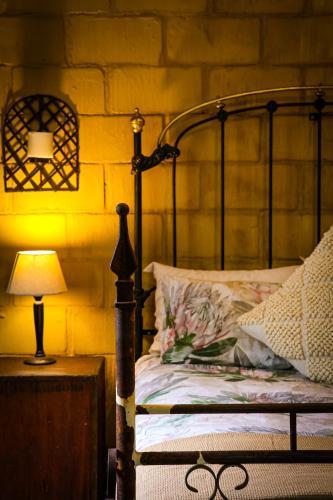 a bedroom with a bed and a lamp on a table at Mercy Tree Manor in eMalahleni