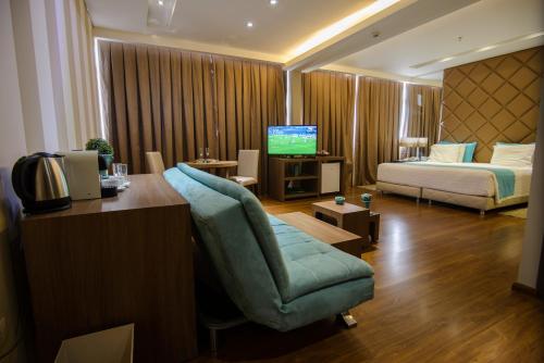 ein Hotelzimmer mit Bett, Stuhl und Fernseher in der Unterkunft Awa Resort Hotel in Encarnación
