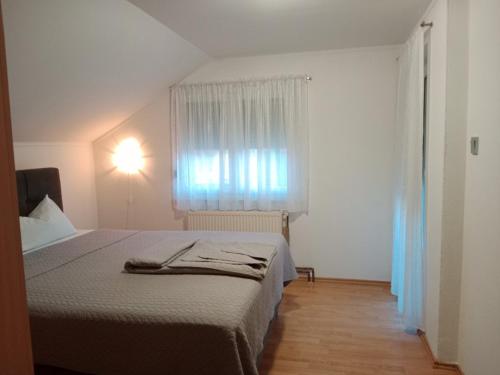 a bedroom with a bed and a window at Apartman Bojan in Prnjavor