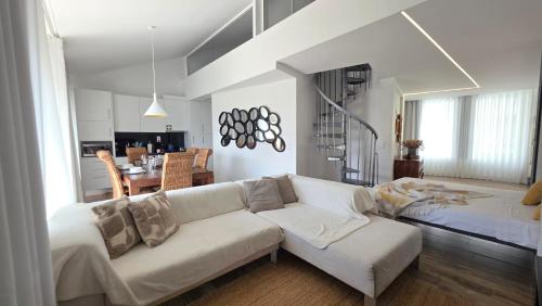 a living room with a white couch and a kitchen at A Proa do Moliceiro - iConik Design Apartments in Aveiro