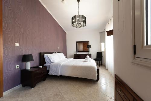 a bedroom with a bed and a table and a chair at Aeolus Villa Chios in Chios